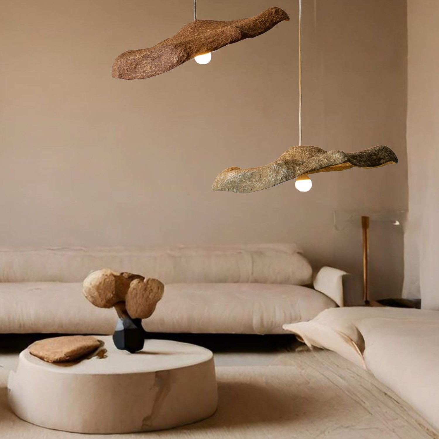 Modern living room with stone-like pendant lights and a neutral color palette. The lamps are teracotta and dark beige color and are from paper mache, made by hand 