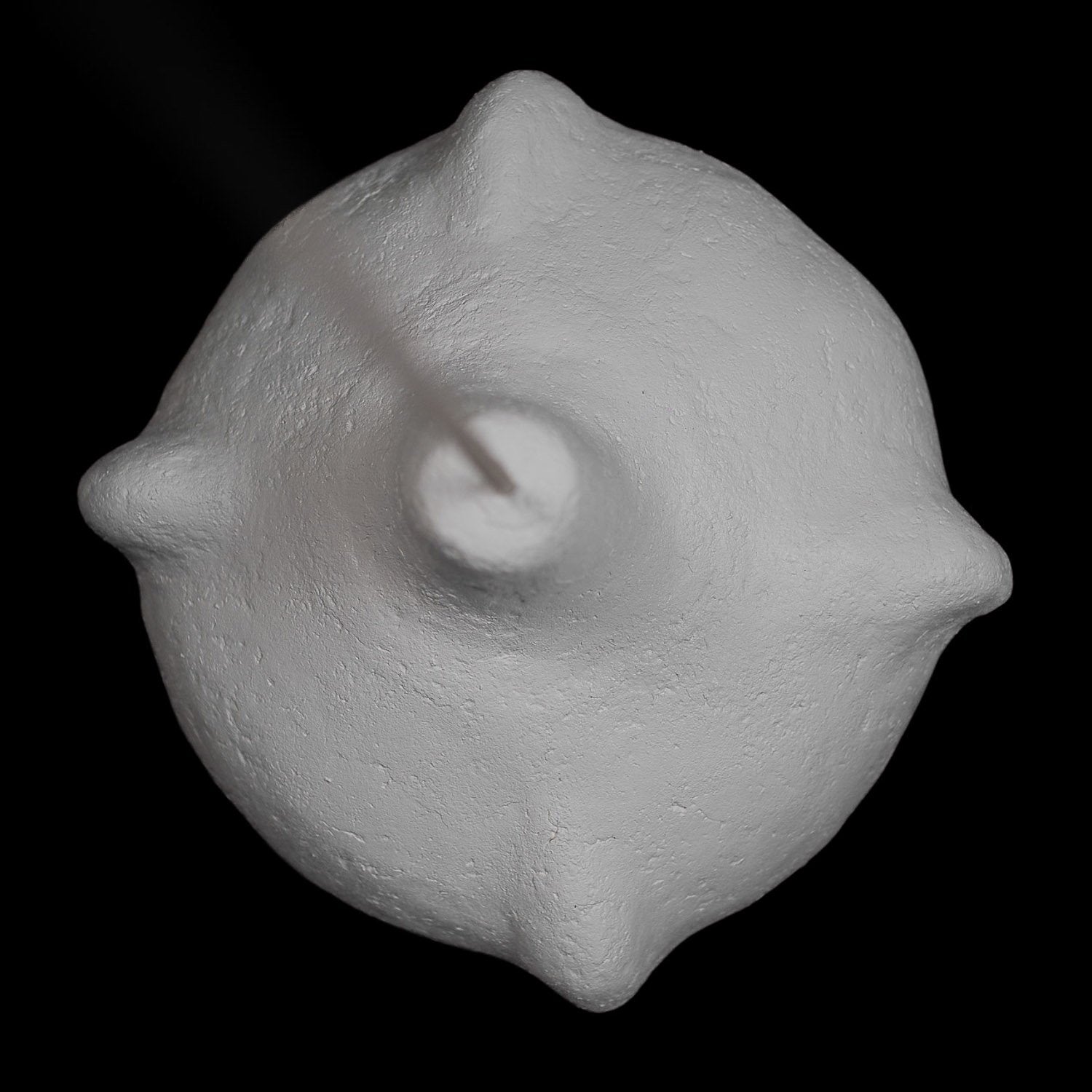 sculptural lampshade seen by above with architectural shape n a off white color made from paper mache