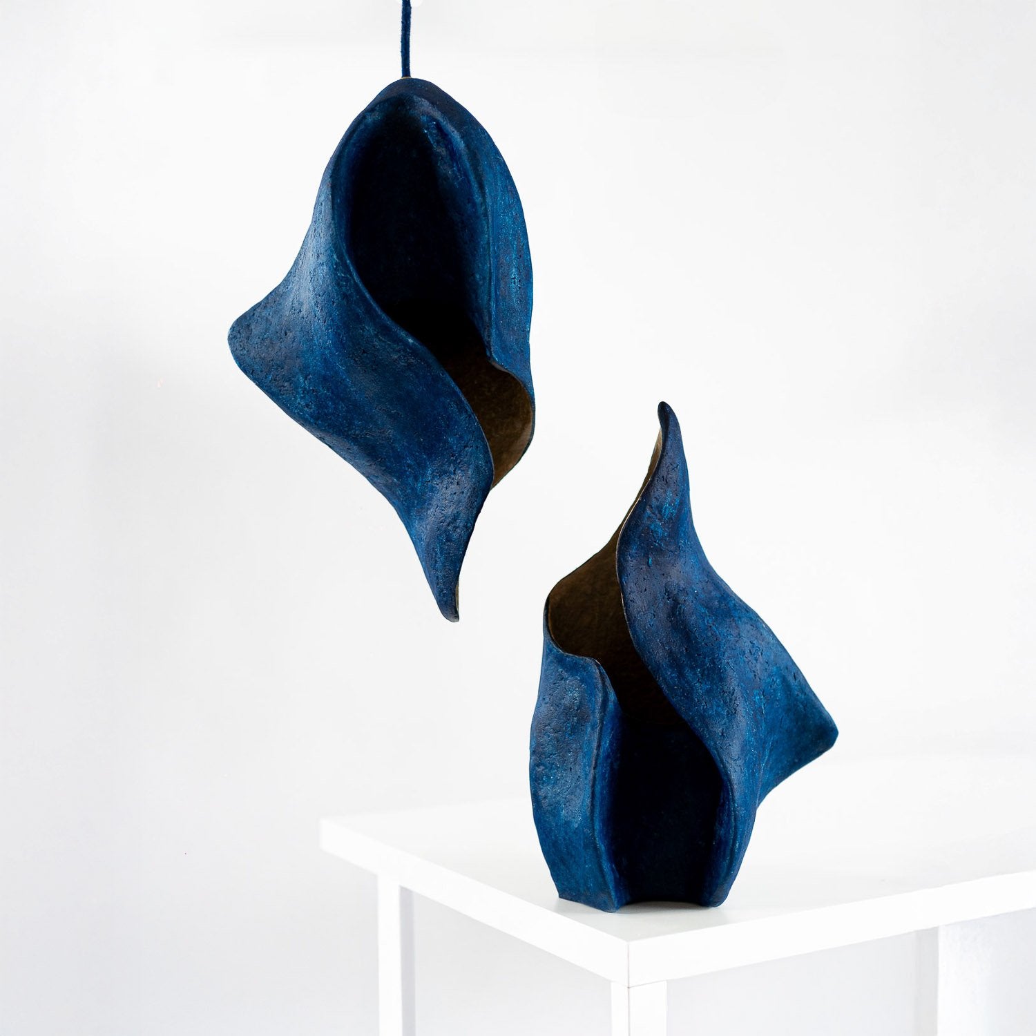 set of lamps for ceiling and table inspired by flames with curvy organic shapes and soft paper mache texture made by hand by lavinia erghelan