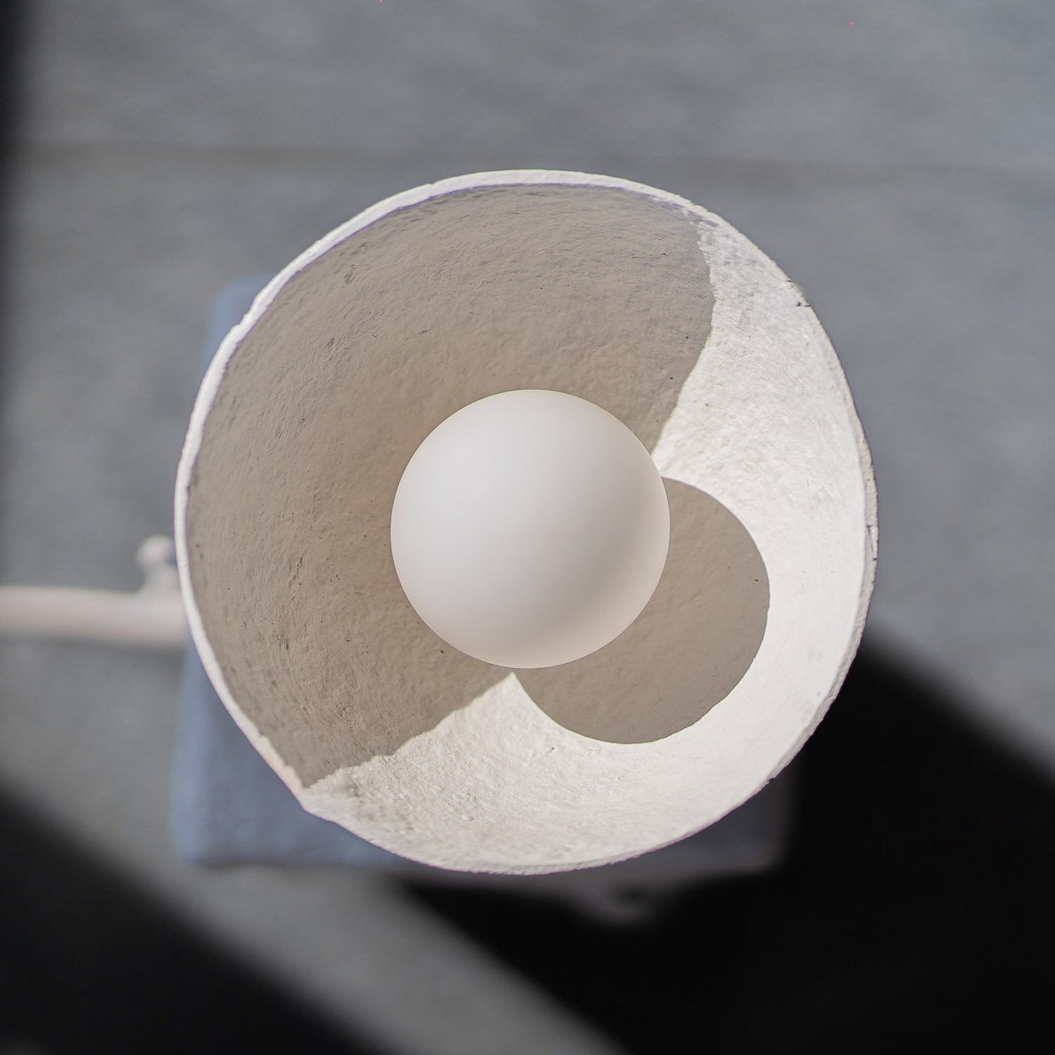 Close-up of a white ball inside a rounded paper mache table lamp