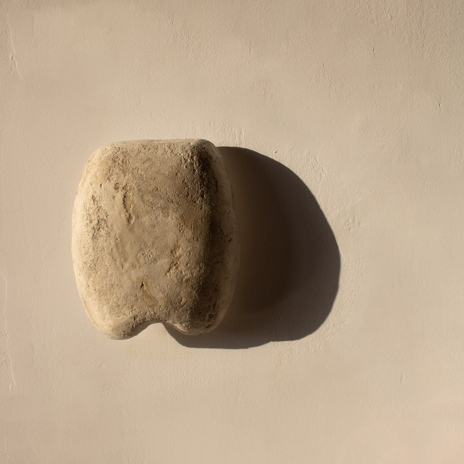 beige stone textured wall light with a sculptural shape from paper mache
